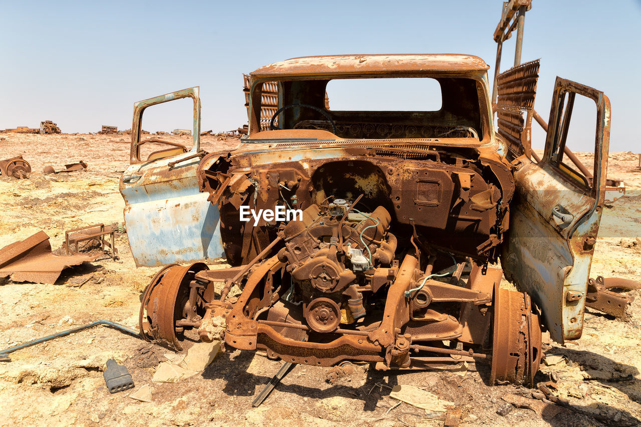 OLD DAMAGED CAR ON ROAD