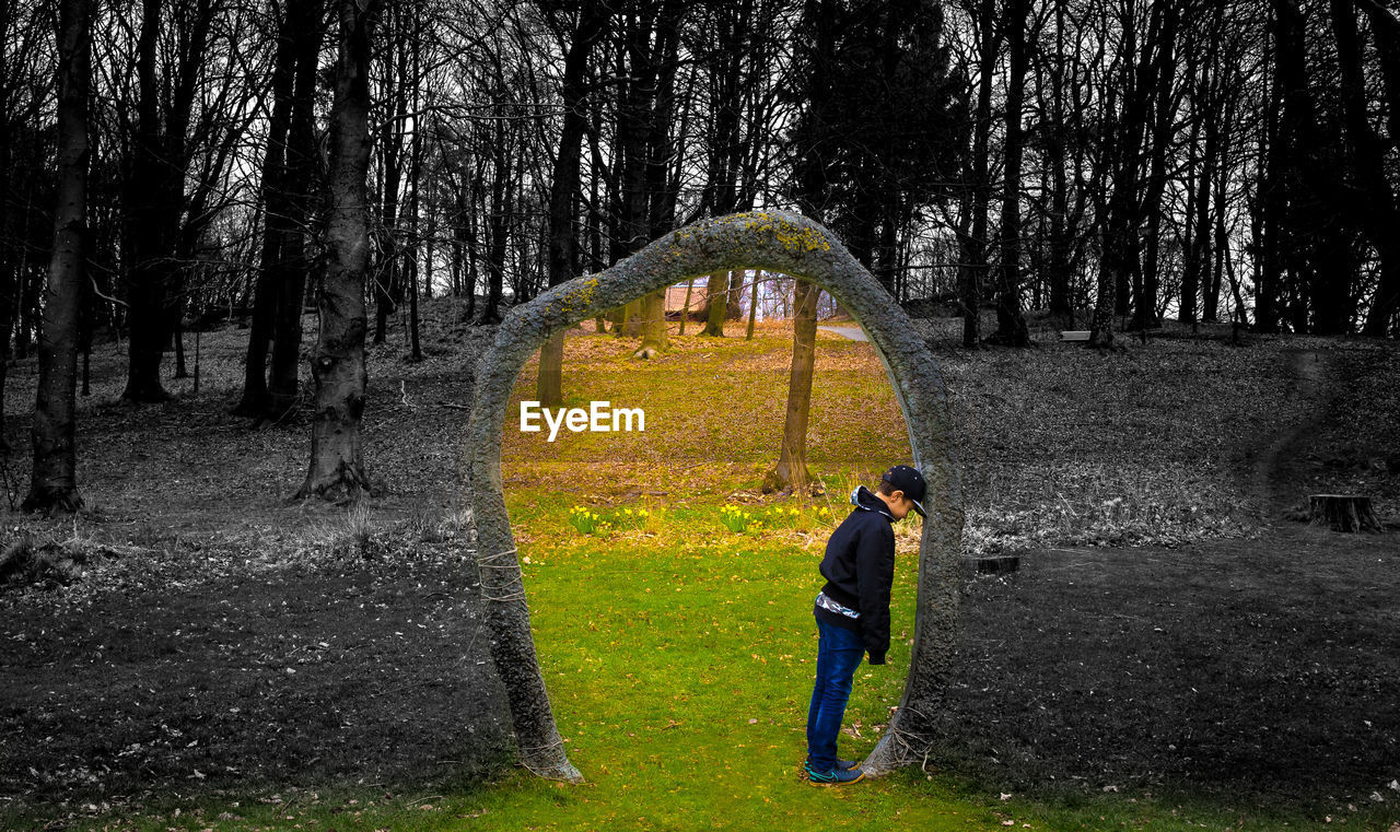 MAN STANDING IN FOREST