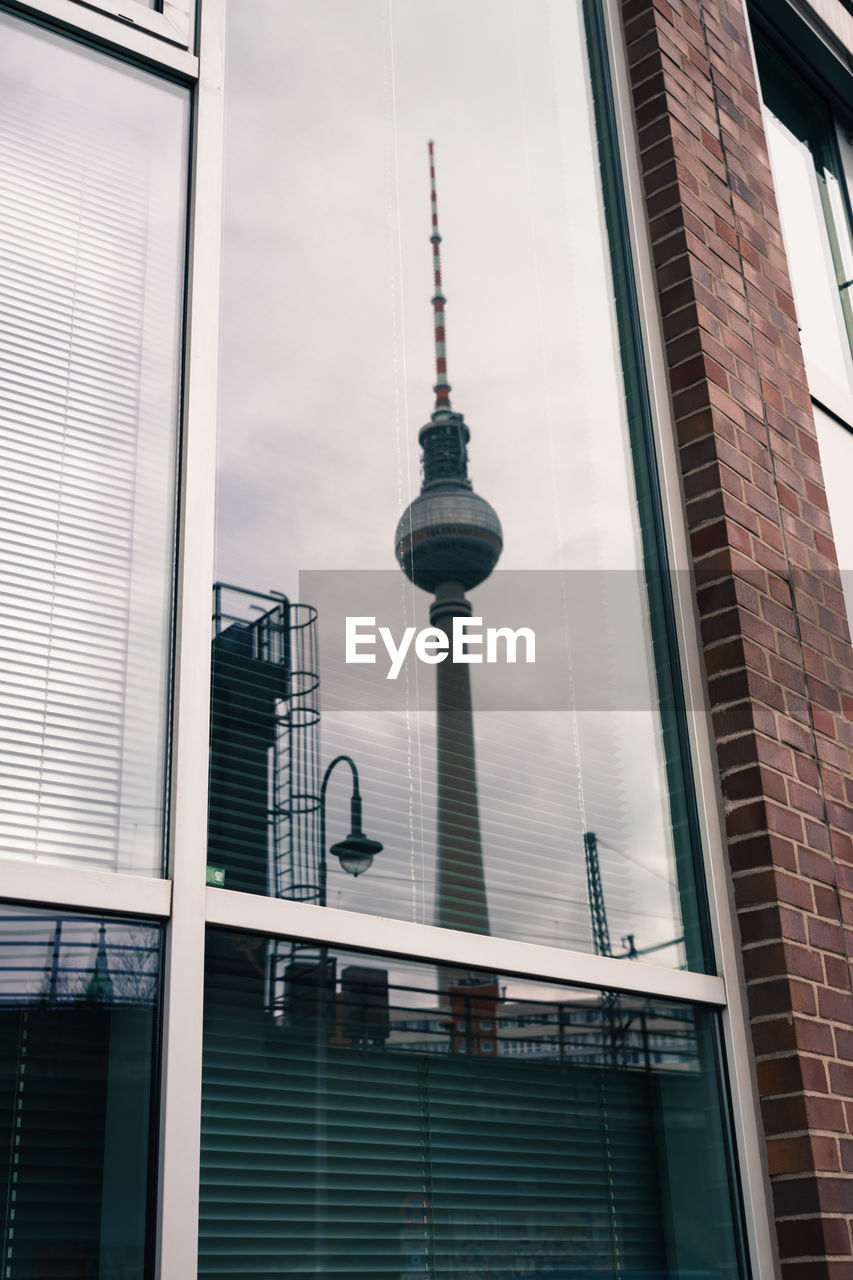 Low angle view of communications tower in city