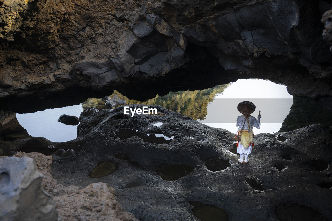 rear view of woman standing on rock