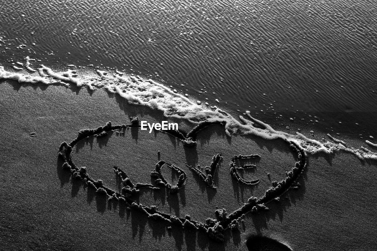 High angle view of love with heart shape written on sandy beach