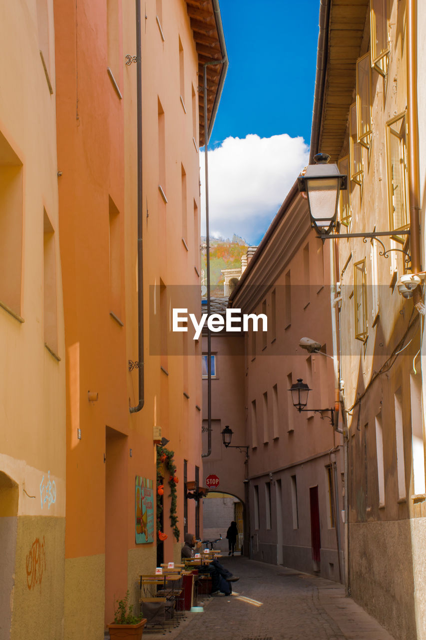 NARROW ALLEY AMIDST BUILDINGS IN CITY