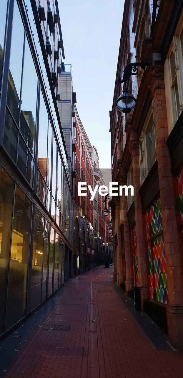 Empty alley amidst buildings in city