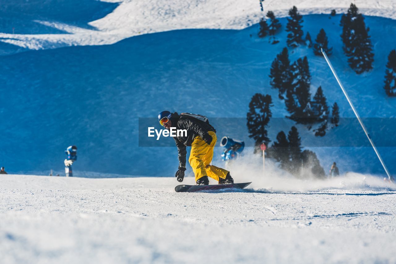 Man snowboarding on snow covered field