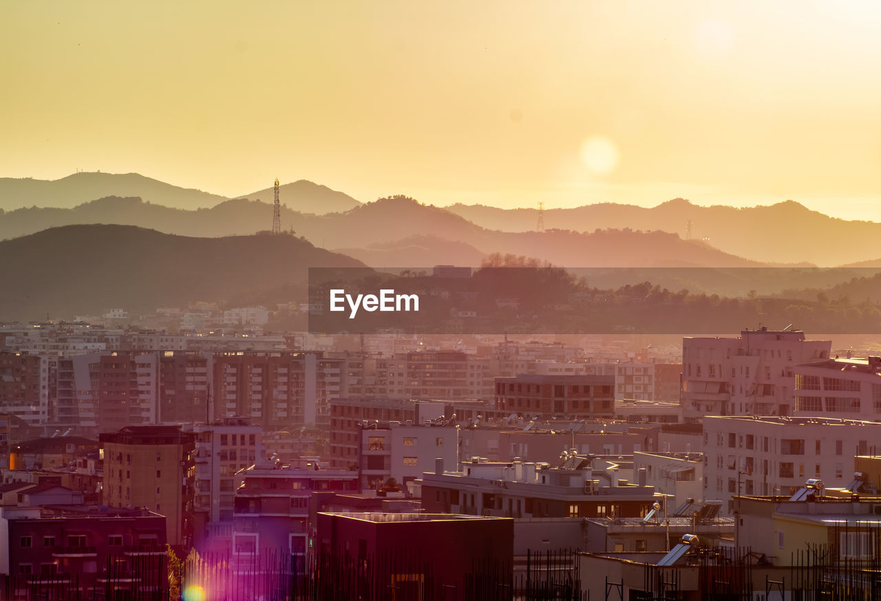 High angle view of buildings in city against sky during sunset