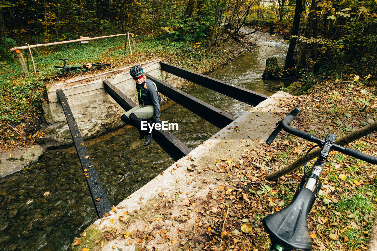High angle view of woman crossing creek 