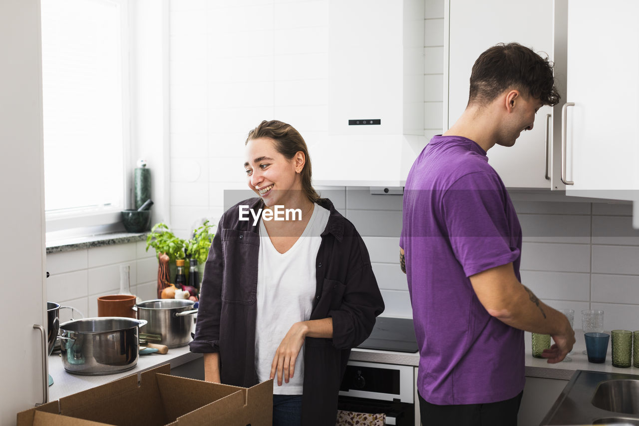 Couple unpacking boxes in kitchen