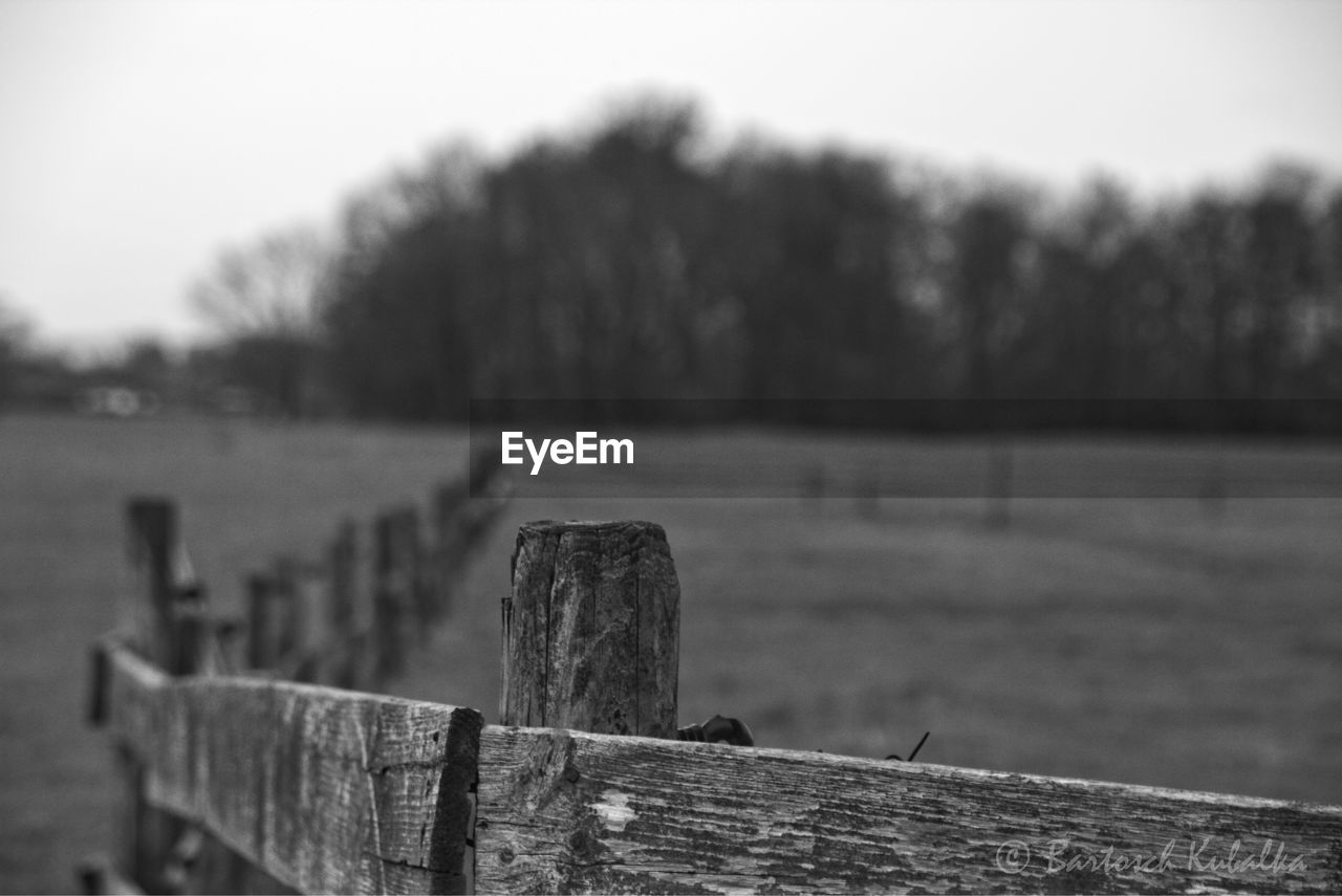 Close-up of wooden post against sky