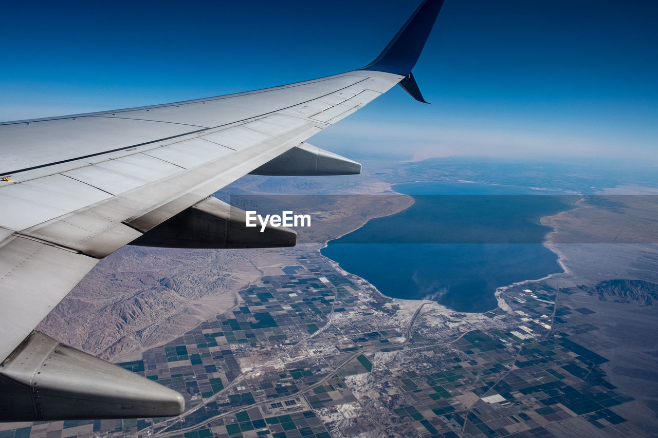 Aircraft wing against clear blue sky