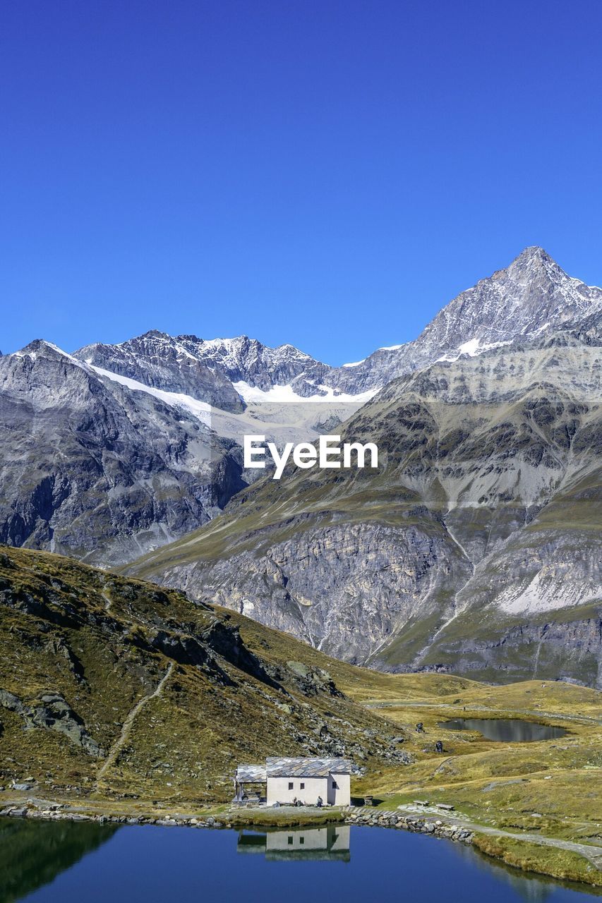 Scenic view of snowcapped mountains against clear blue sky