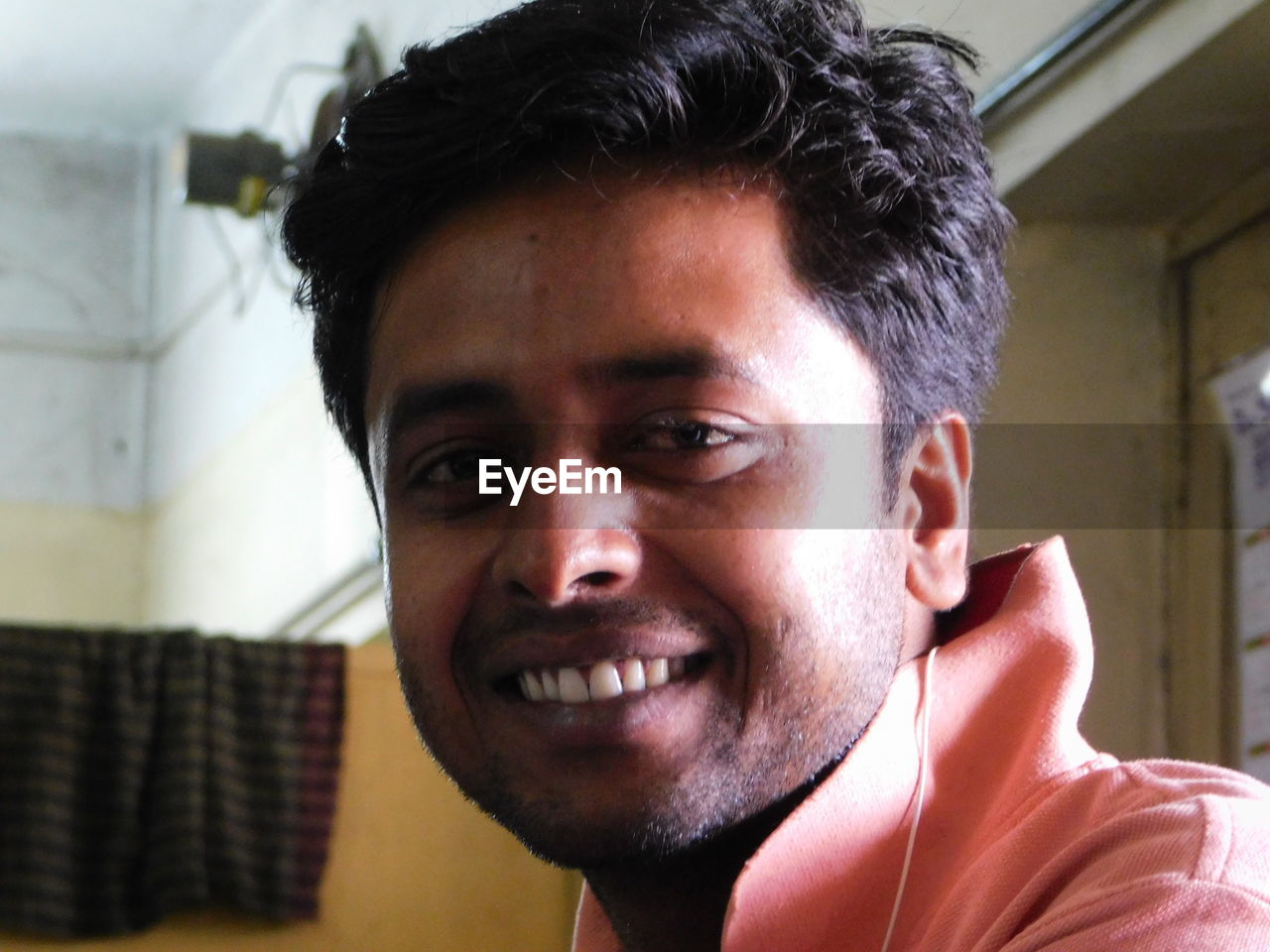 Close-up portrait of smiling young man at home