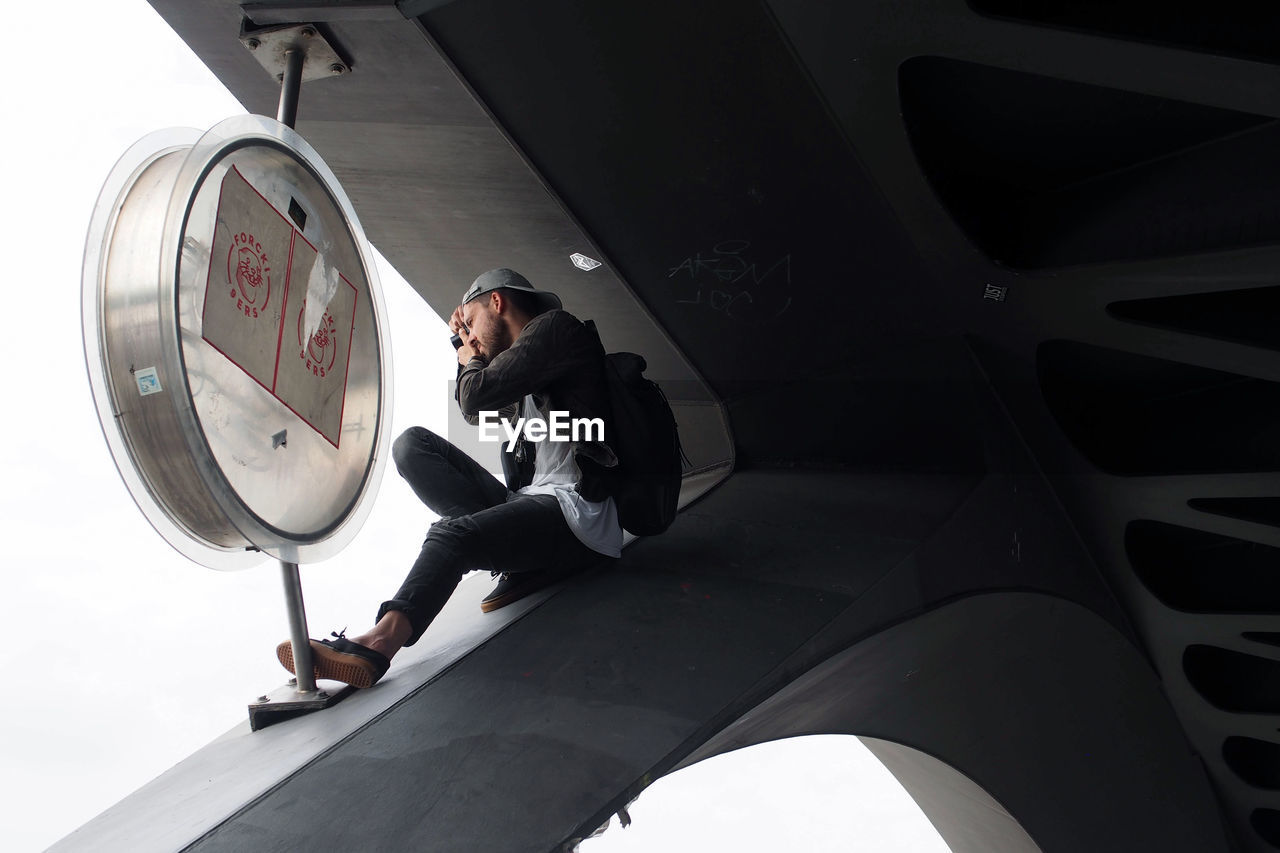 Man taking a photo from above on a bridge