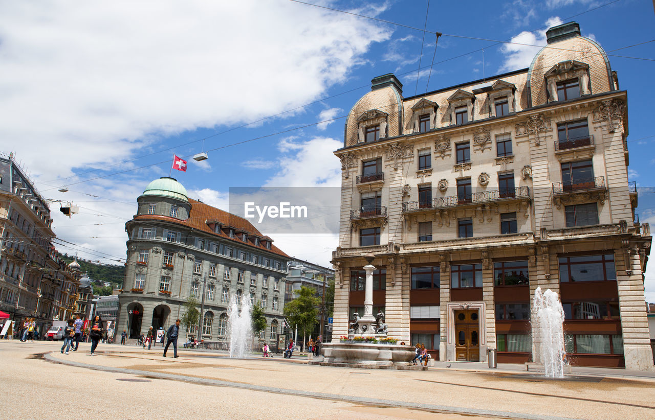 BUILDINGS IN CITY AGAINST CLOUDY SKY