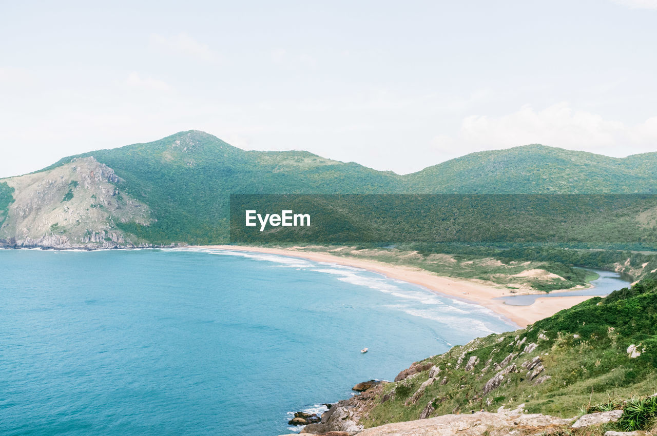 Scenic view of sea and mountains against sky