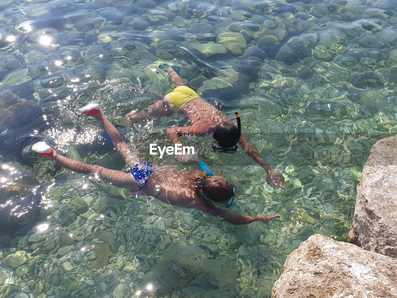 High angle view of siblings swimming in sea
