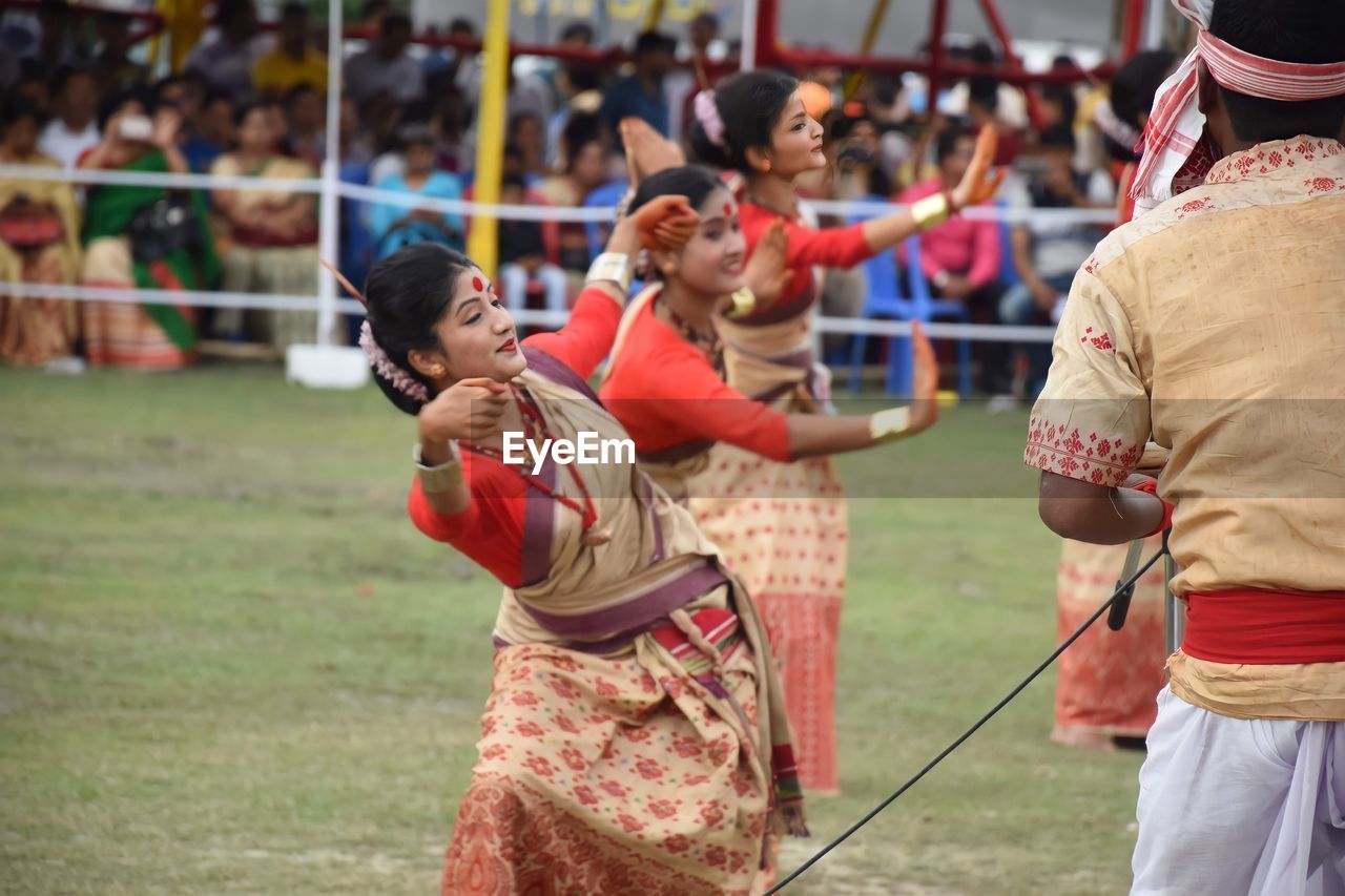 Group of people dancing bihy outdoors in assam. 