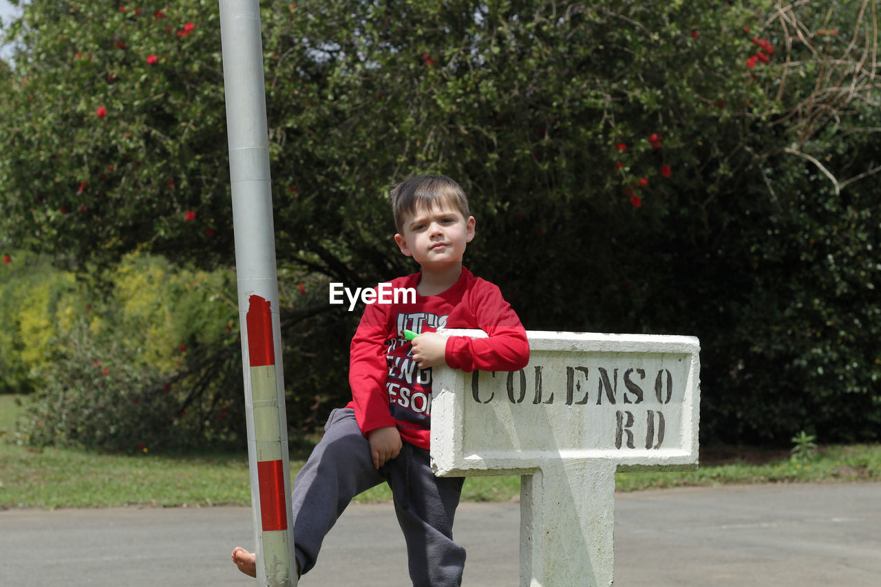 FULL LENGTH OF BOY WITH ARMS RAISED