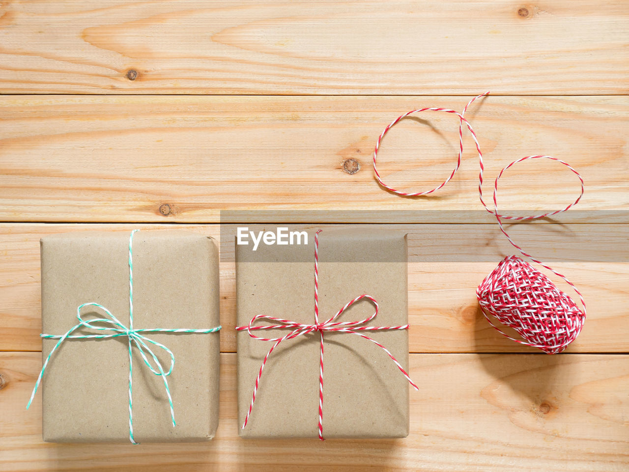 wood, indoors, hardwood floor, ribbon, no people, gift, pink, box, bow, tied bow, high angle view, still life, flooring, table, string, studio shot, celebration, material, holiday, container, art, thread, tied up, creativity, directly above, close-up, decoration, christmas