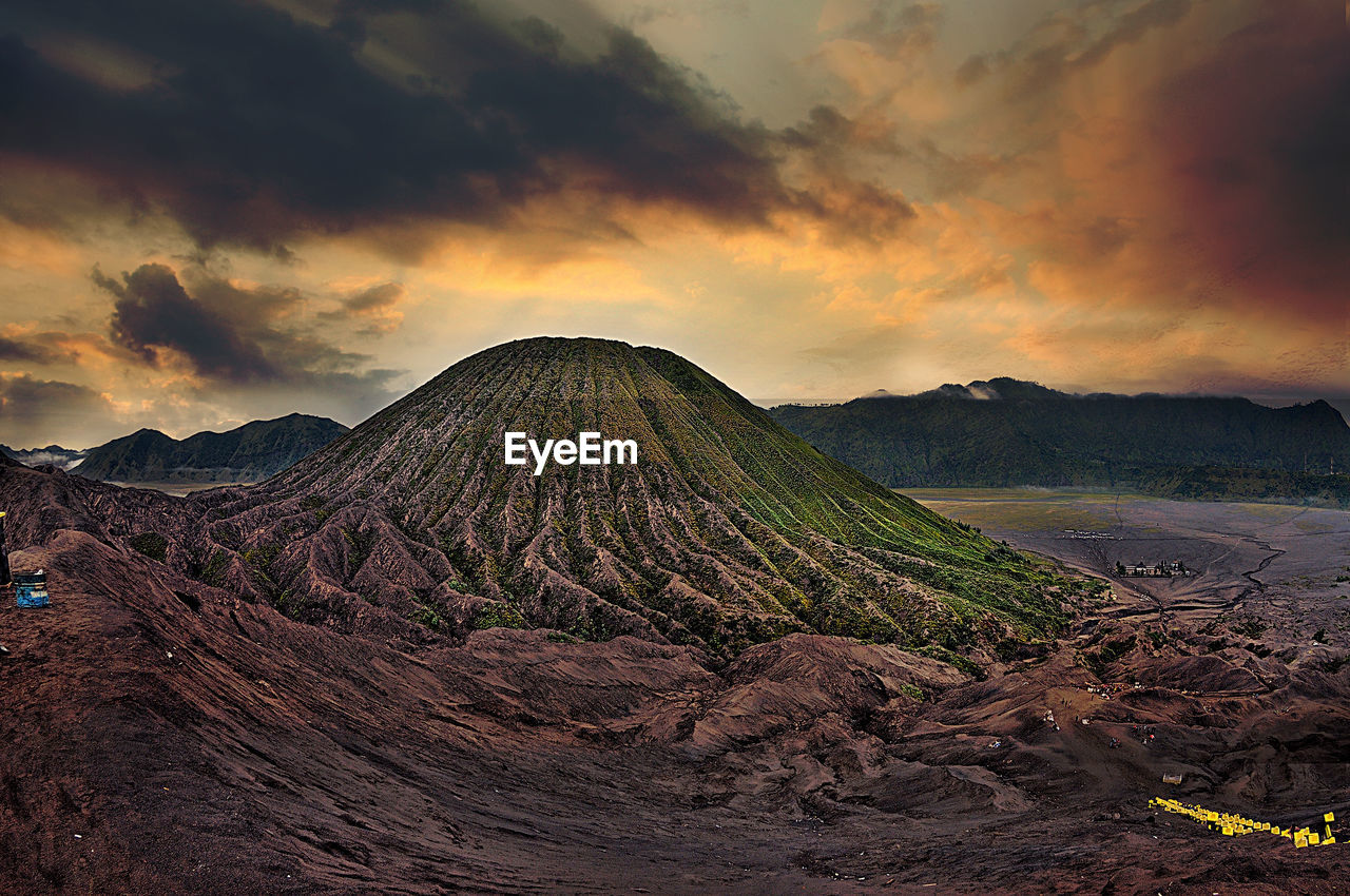 VIEW OF VOLCANIC LANDSCAPE AGAINST CLOUDY SKY