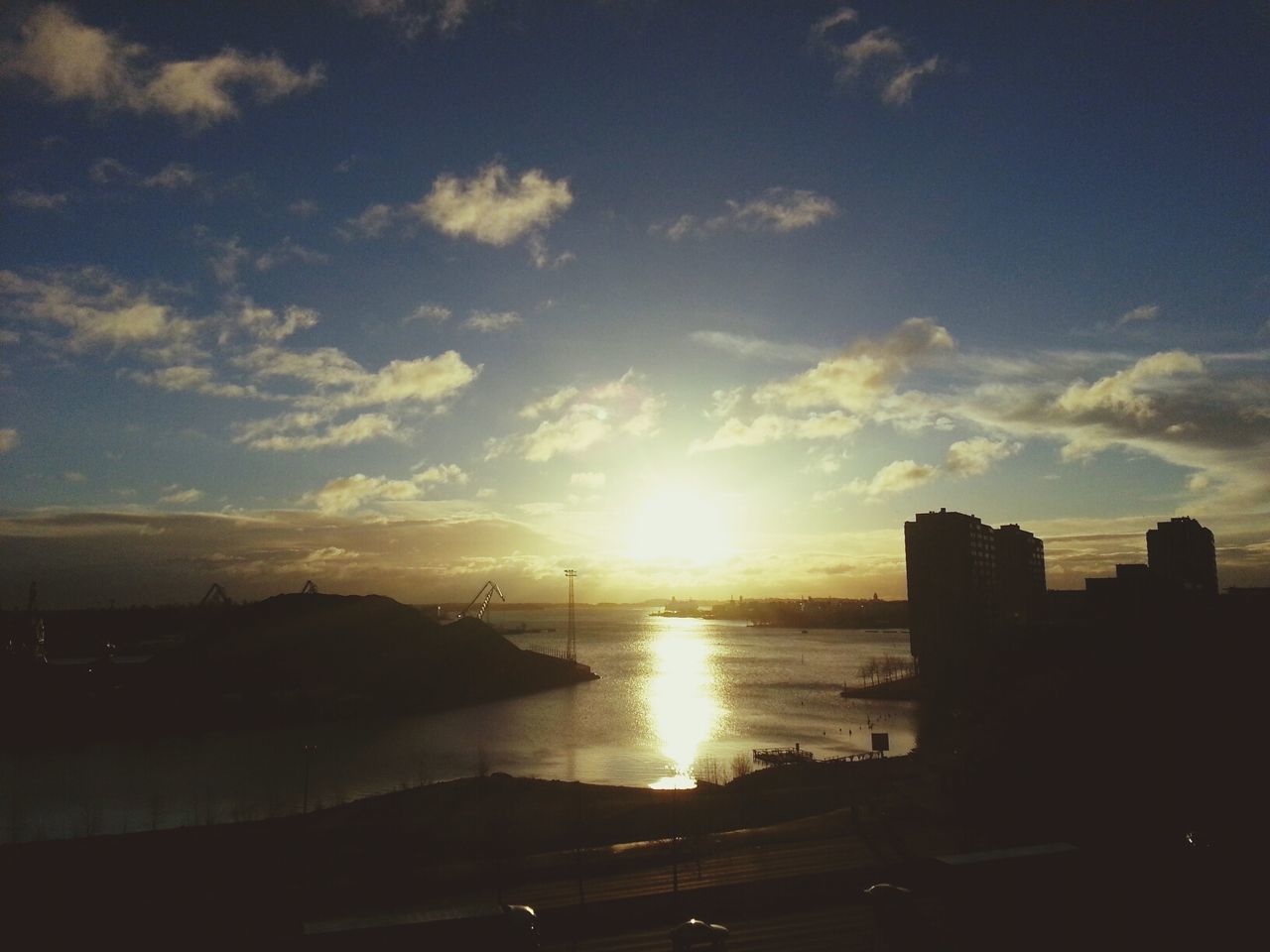 High angle view of buildings by river against sky