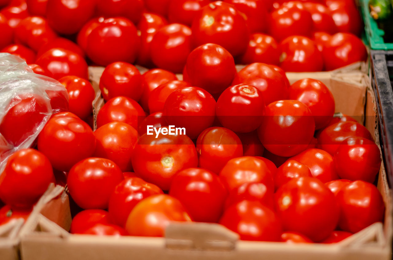 Red tomatoes in boxes. sale of tomatoes. delicious ingredient for salads. healthy eating