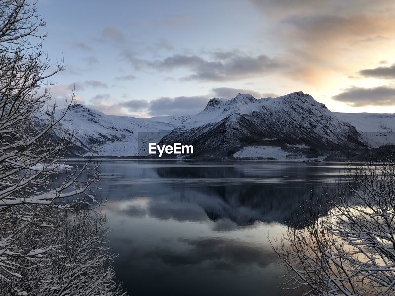 Scenic view of lake and snowcapped mountains against sky