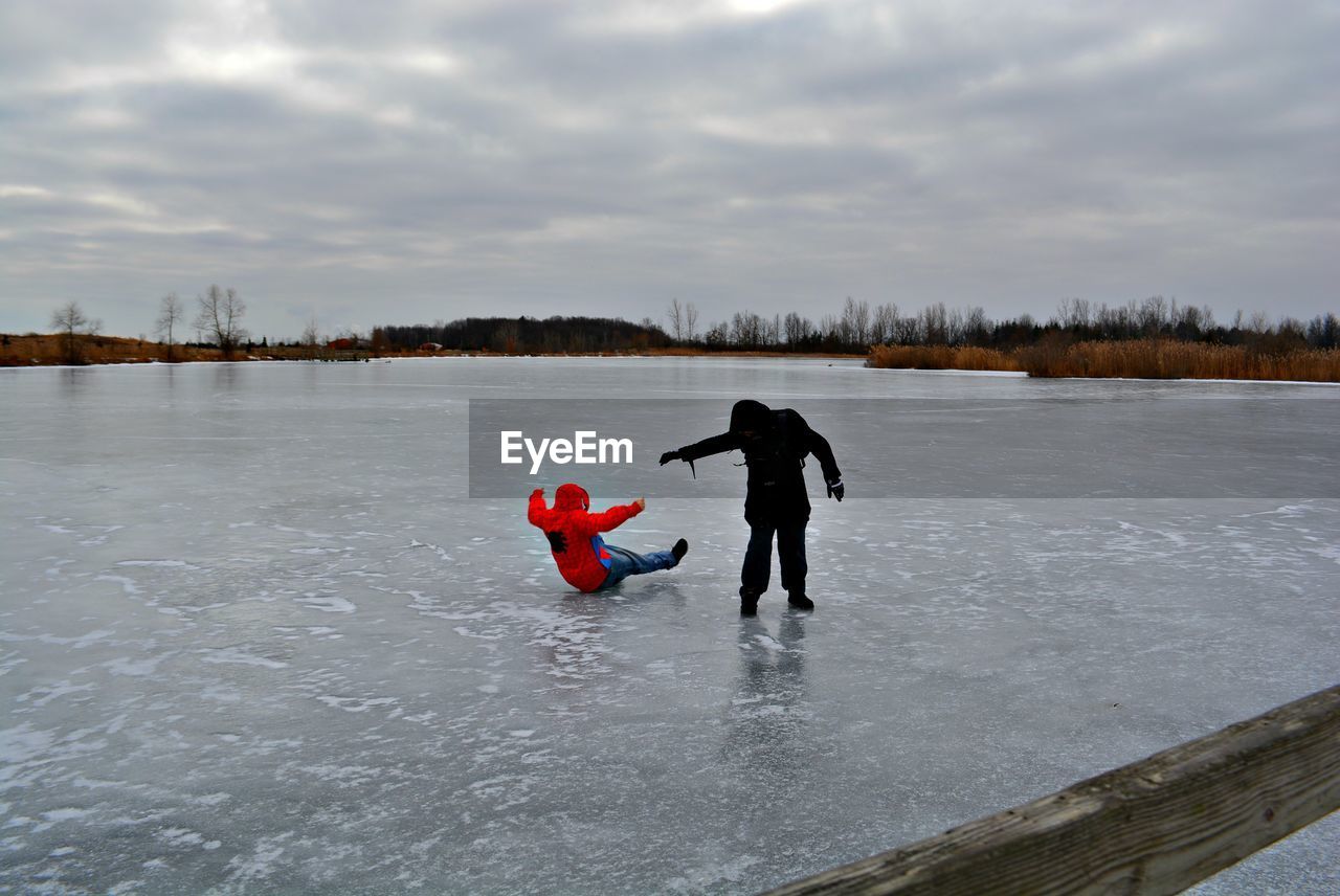 BOY ON LAKE DURING WINTER