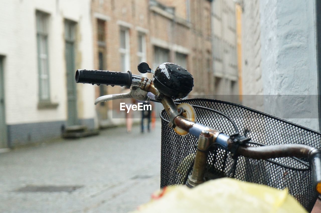 CLOSE-UP OF BICYCLE ON STREET BY BUILDING