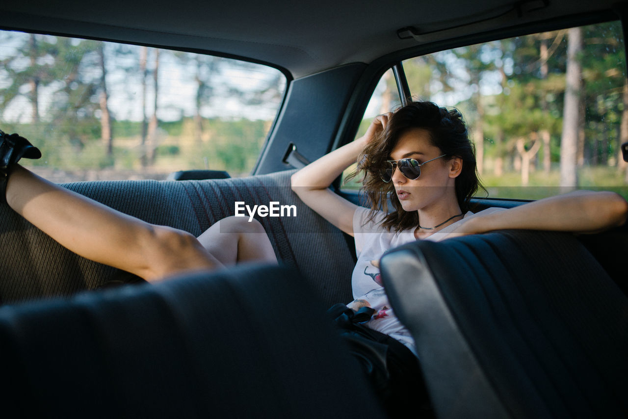 Portrait of a hipster girl in the back seat of a car.