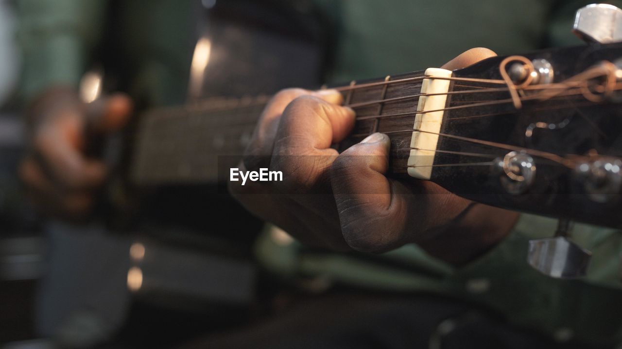 Cropped hand playing guitar