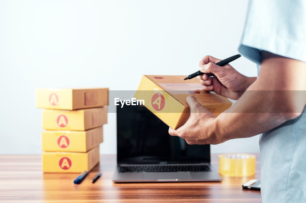 cropped hand of man holding toy blocks on table