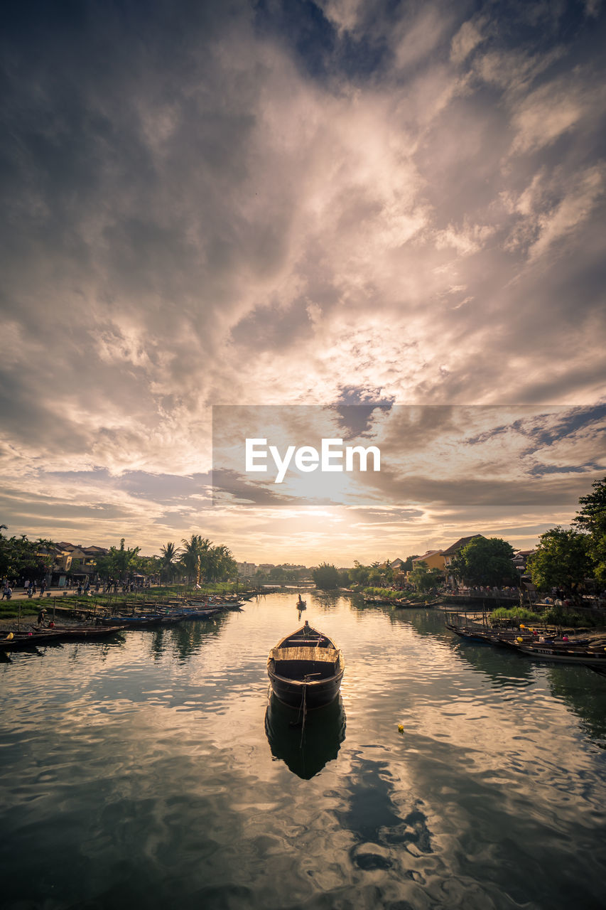 Boat in lake against sky during sunset