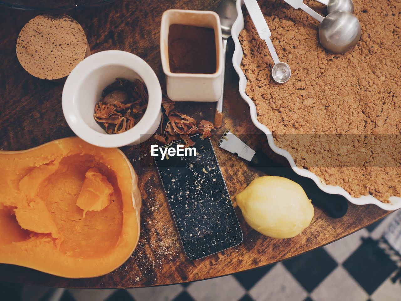 High angle view of mobile phone with spices and pie on table