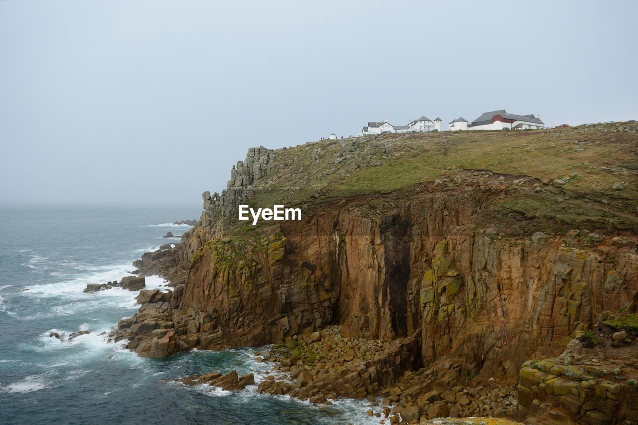 Scenic view of sea and cliff against clear sky