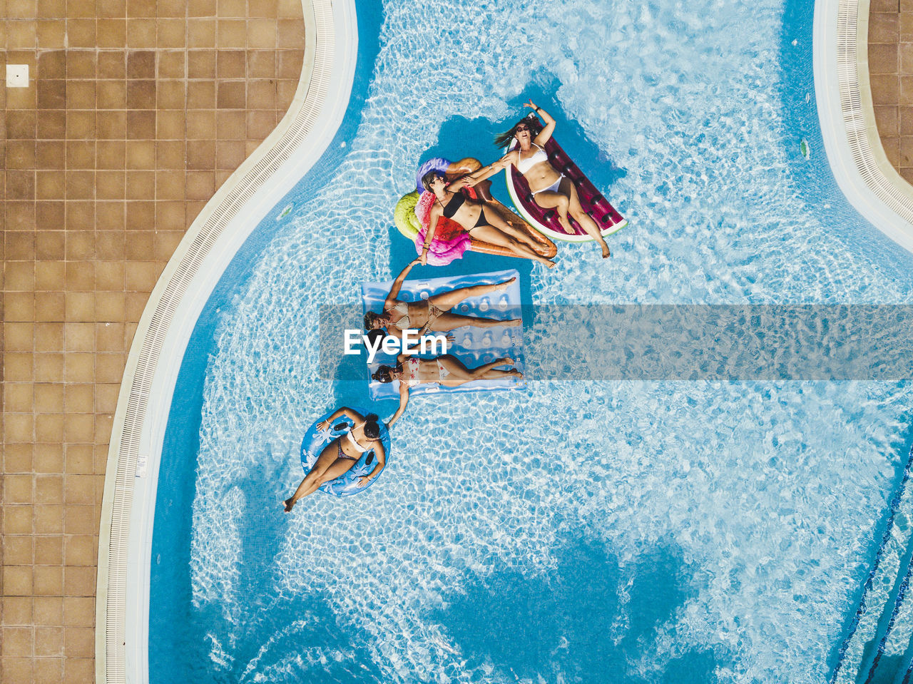 Directly above shot of people relaxing in swimming pool