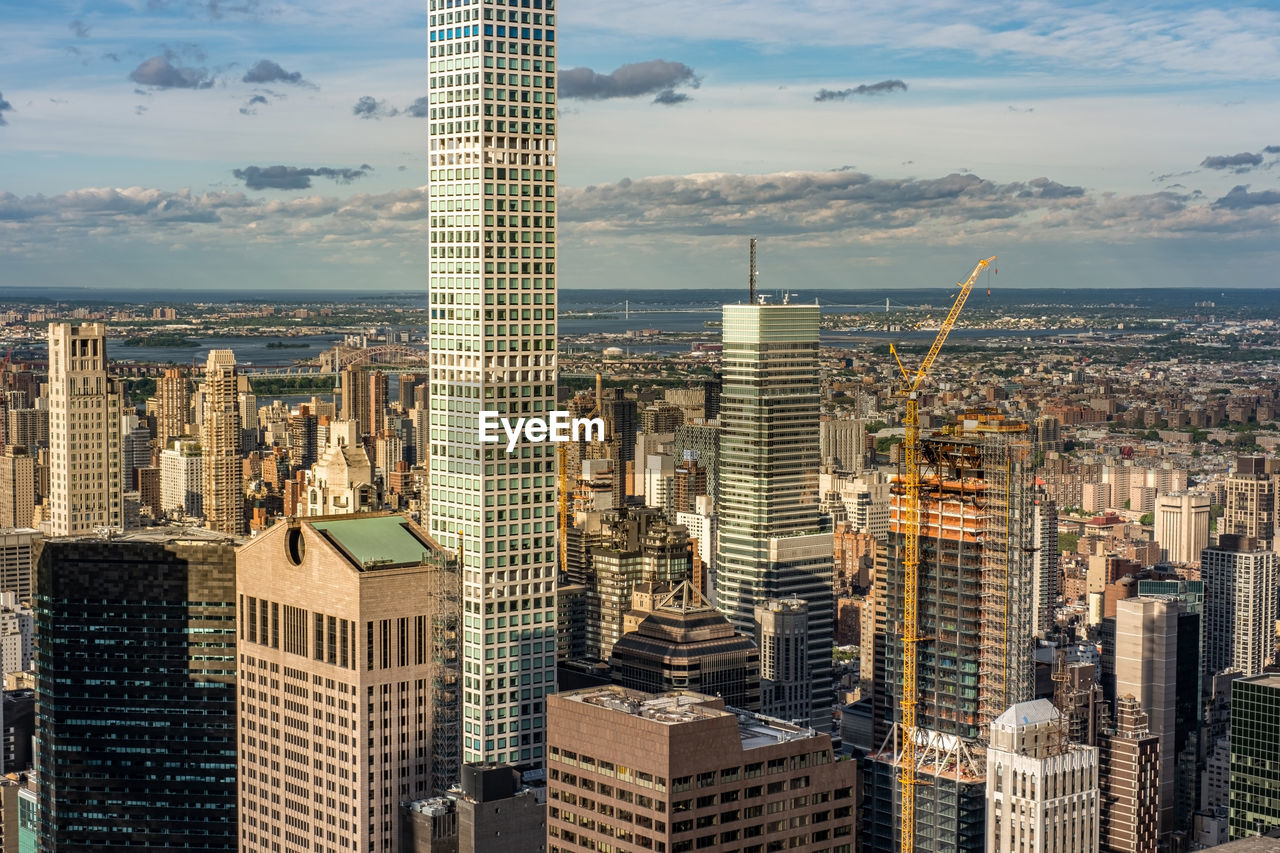 MODERN BUILDINGS IN CITY AGAINST CLOUDY SKY