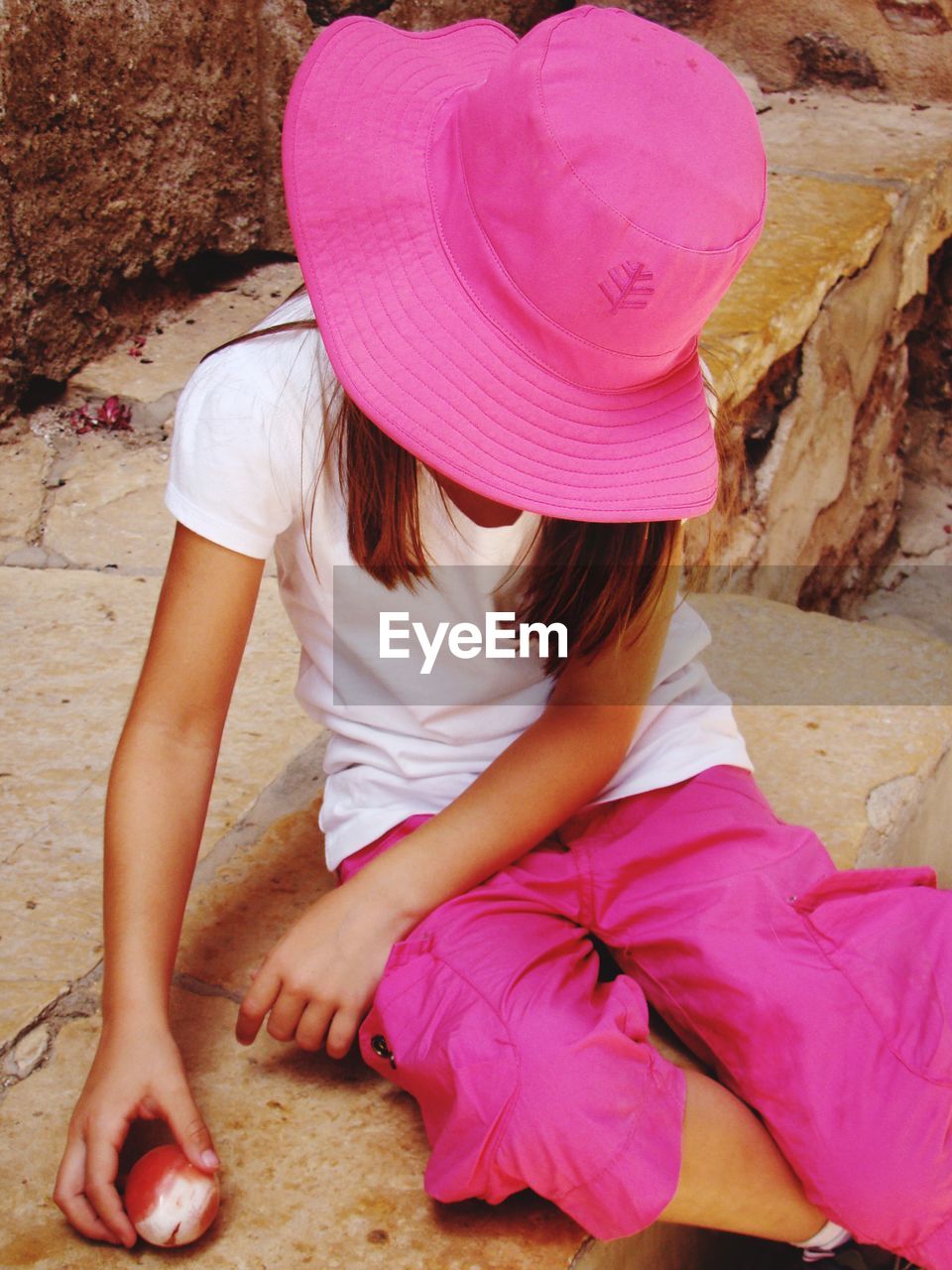 YOUNG WOMAN SITTING ON SAND