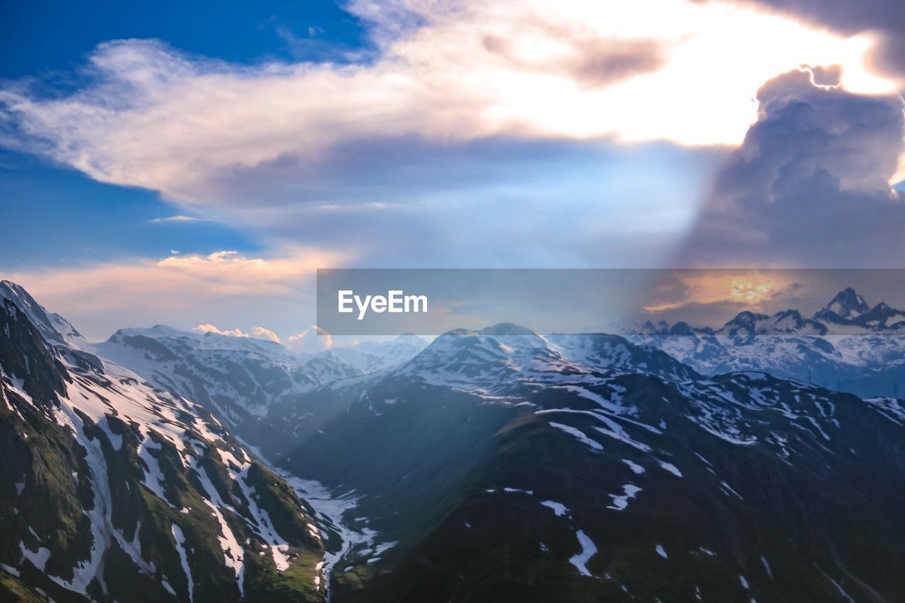 Scenic view of snowcapped mountains against sky during sunset