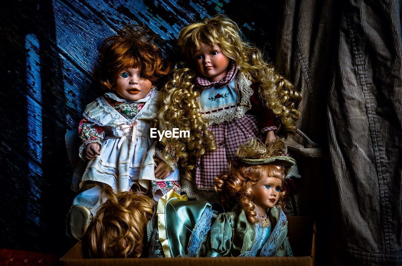 Abandoned dolls against wooden wall