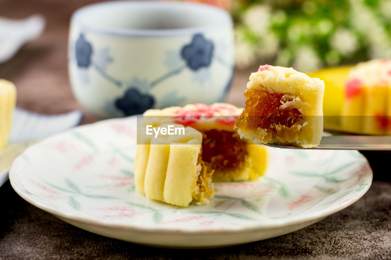 CLOSE-UP OF CAKE SERVED IN PLATE WITH TEA