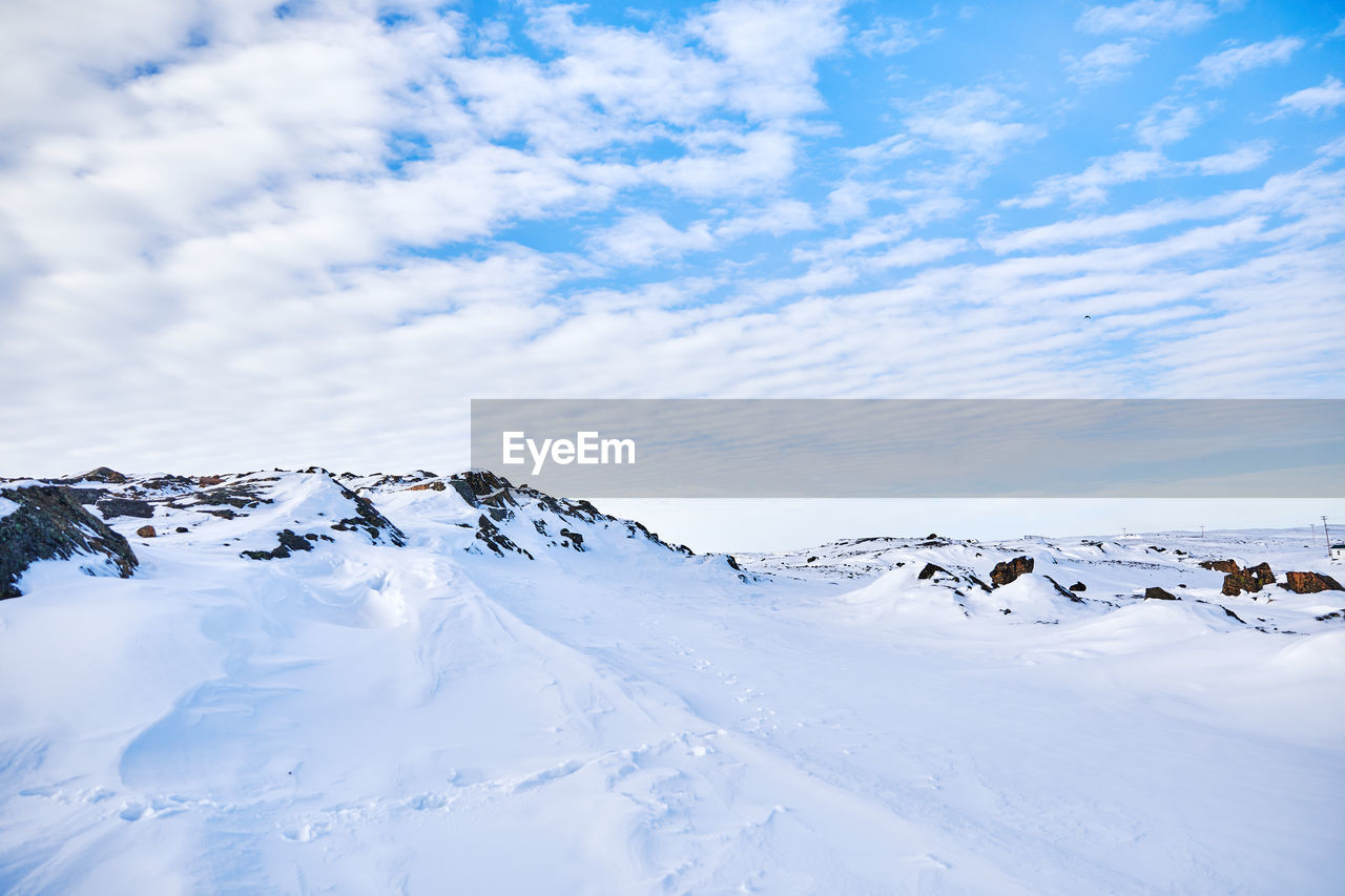 Snow covered landscape against sky