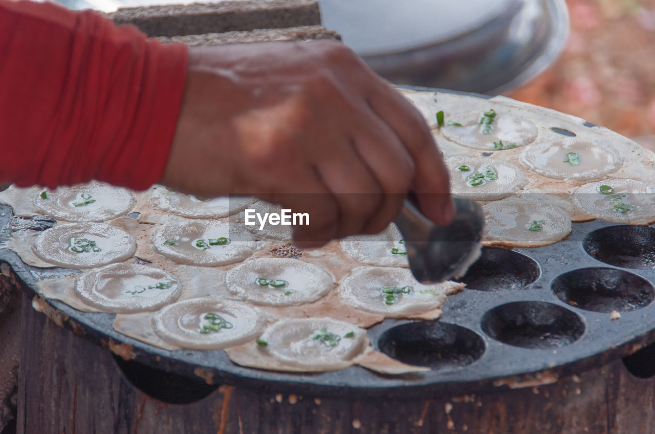 HIGH ANGLE VIEW OF MAN PREPARING FOOD