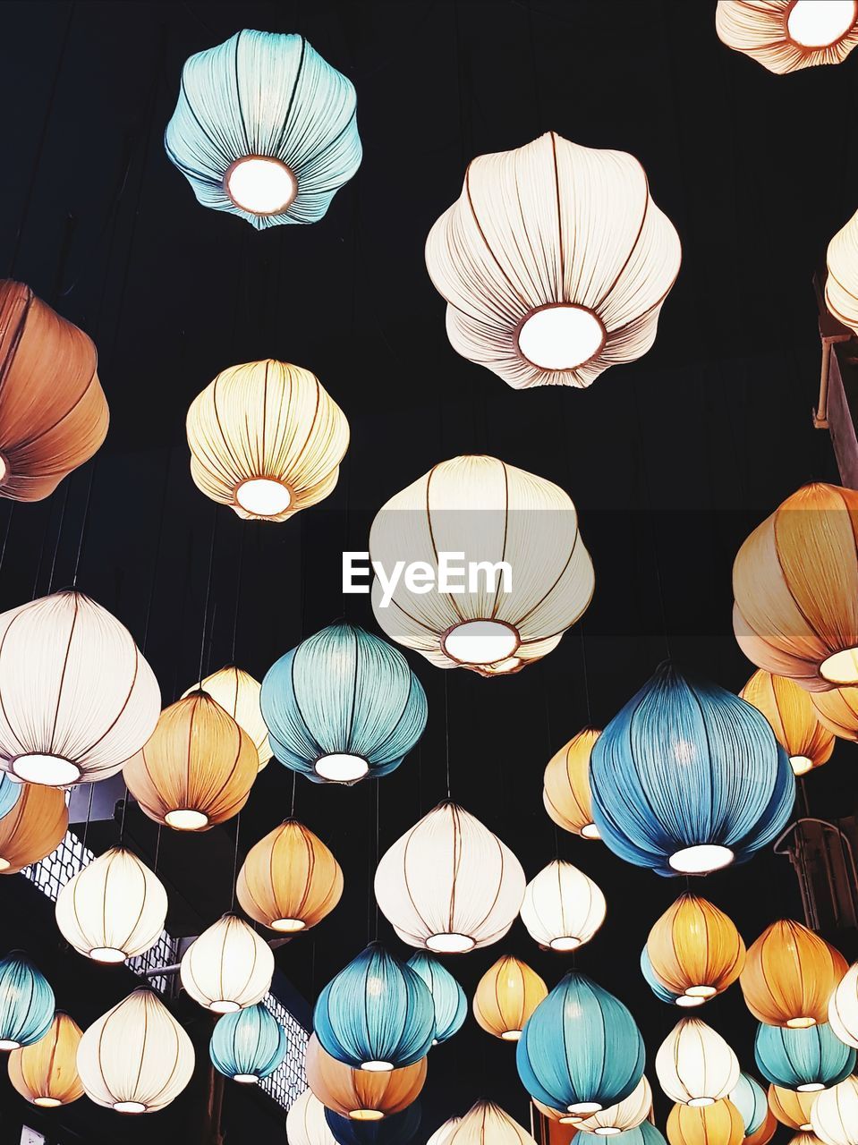 LOW ANGLE VIEW OF ILLUMINATED LANTERNS HANGING AT CEILING