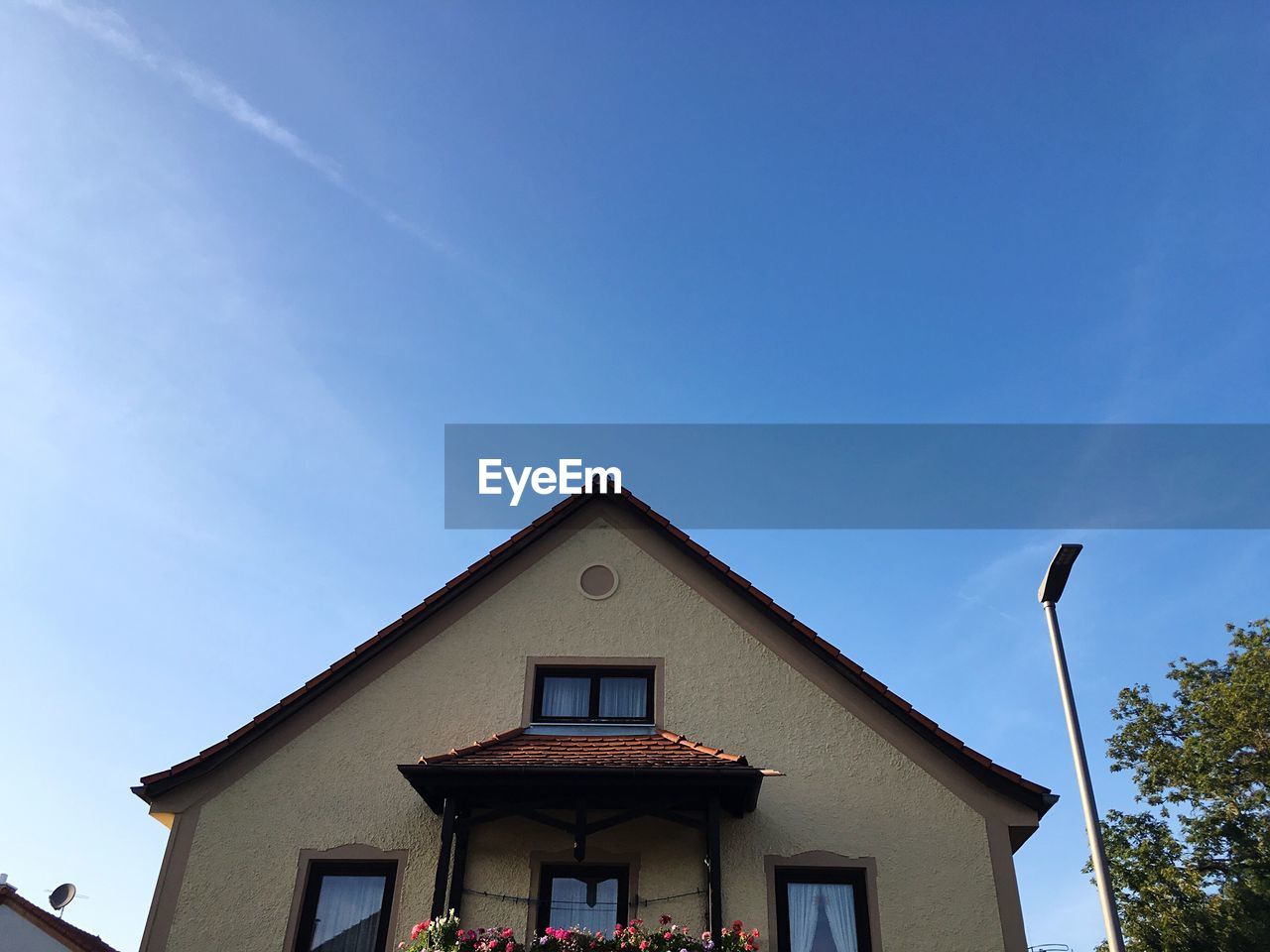 Low angle view of house against sky during sunny day