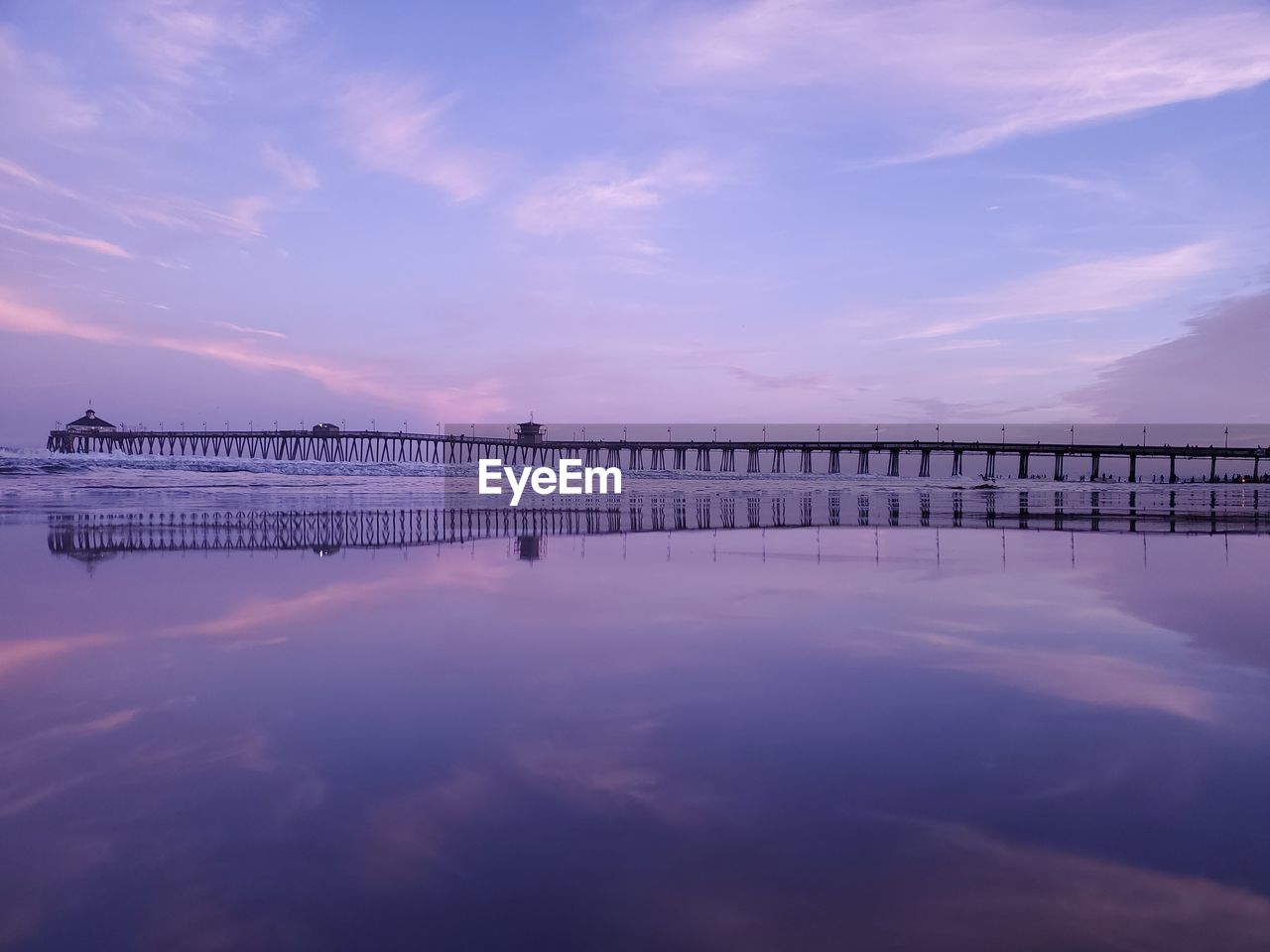 Pier over sea against sky during sunset