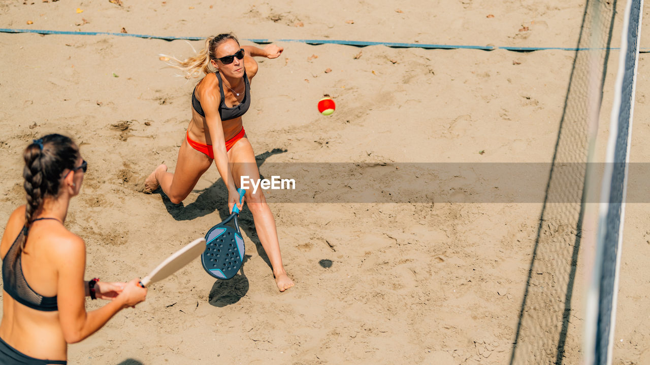 Female team playing beach tennis