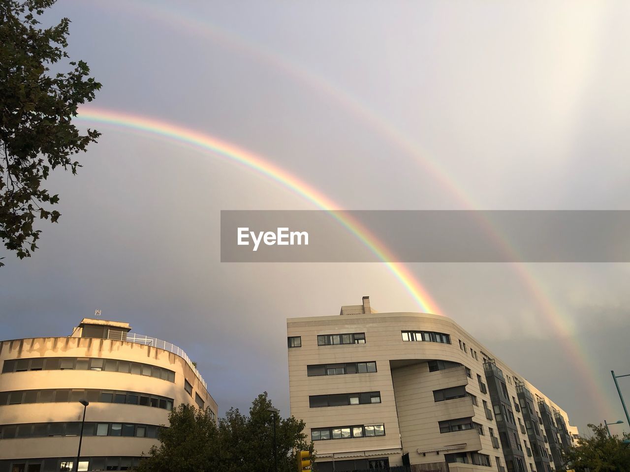 LOW ANGLE VIEW OF RAINBOW OVER BUILDING IN CITY