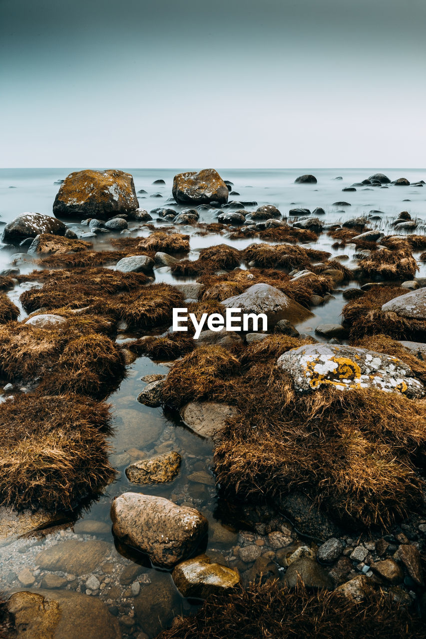 Rocks on beach against sky