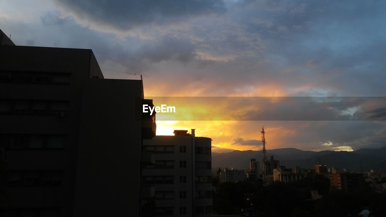 SILHOUETTE BUILDINGS AGAINST SKY AT SUNSET