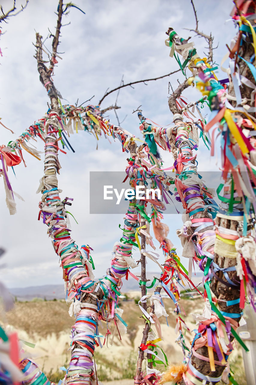 LOW ANGLE VIEW OF DECORATIONS HANGING ON STREET AGAINST SKY